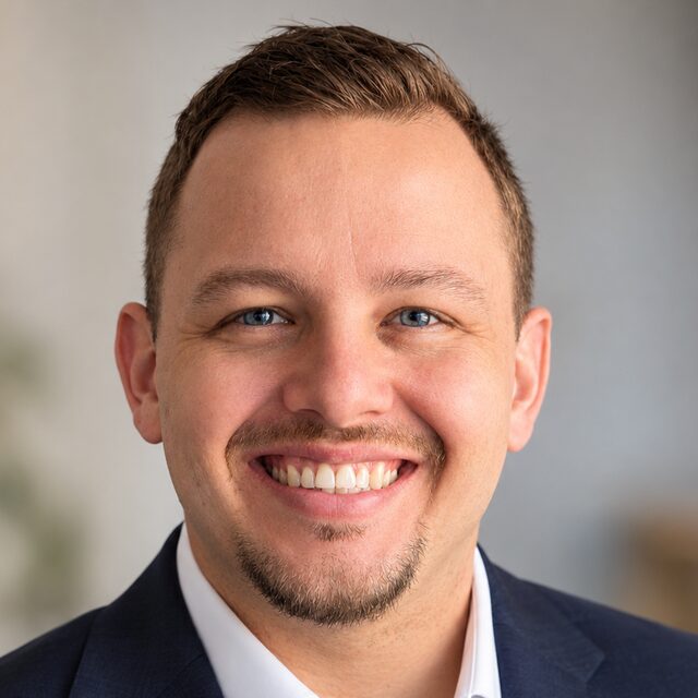 Tyler Shafer, PE, founder of Silver Otter Systems, smiling in a navy blazer